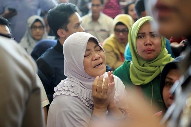 A relative of passengers prays as she and others wait for news on a Lion Air plane that crashed off Java Island at Depati Amir Airport in Pangkal Pinang, Indonesia Monday, Oct. 29, 2018. Indonesia disaster agency says that the Lion Air Boeing 737-800 plane crashed into sea shortly after it left Indonesia's capital Monday morning.