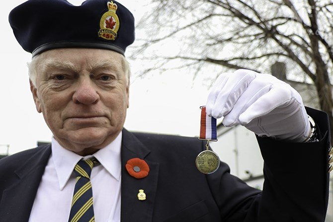 Peter Miedema, who sang 'O Canada' at the ceremony, shows his father's medal who was a member of the Allied underground in the Netherlands. The red, white, and blue symbolize the Dutch flag and the medal represents the 50th anniversary of the 1945 liberation of the Netherlands.