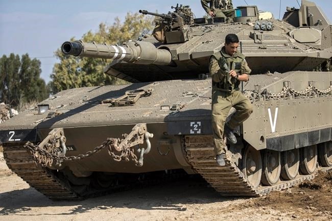 An Israeli soldier jumps off a tank near the Israel Gaza border, Tuesday, Nov. 13, 2018.