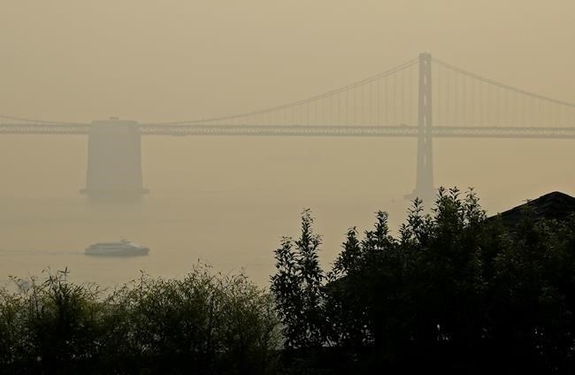 A ferryboat and the San Francisco-Oakland Bay Bridge are obscured due to smoke and haze from wildfires Monday, Nov. 19, 2018, in San Francisco.