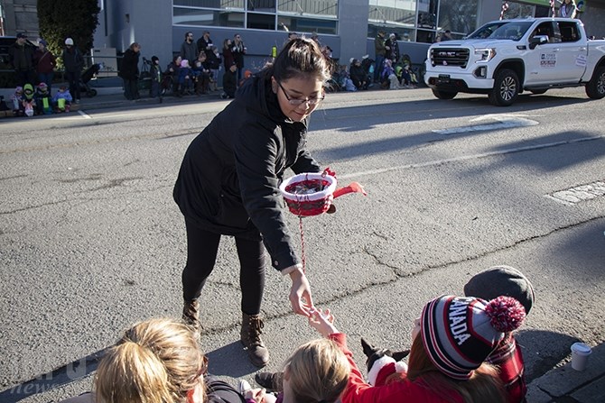 A girl hands out candy to spectators at the annual Kamloops Santa Claus Parade.