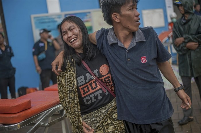 A woman reacts after identifying a relative among the bodies of tsunami victims in Carita, Indonesia, Sunday, Dec. 23, 2018. The tsunami occurred after the eruption of a volcano around Indonesia's Sunda Strait during a busy holiday weekend, sending water crashing ashore and sweeping away hotels, hundreds of houses and people attending a beach concert.