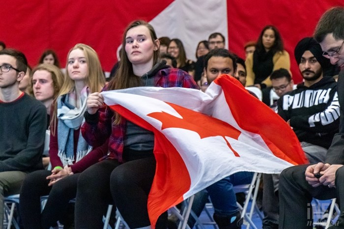 A woman waves a Canadian flag as she sits in the front row of Justin Trudeau's town hall meeting at TRU on Wednesday, Jan. 9, 2019.