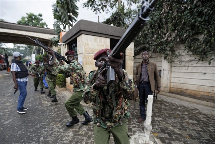 Kenyan security forces aim their weapons up at buildings as they run through a hotel complex in Nairobi, Kenya Tuesday, Jan. 15, 2019. Terrorists attacked an upscale hotel complex in Kenya's capital Tuesday, sending people fleeing in panic as explosions and heavy gunfire reverberated through the neighborhood.
