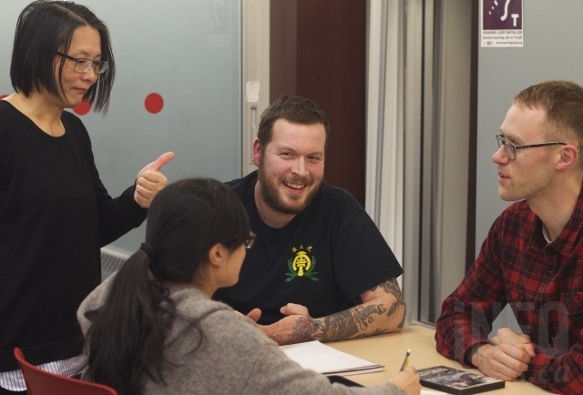 Marriana Chen, left, checks in on Mandarin language learners Luke Mortenson, centre, and Brendan Ferguson. 