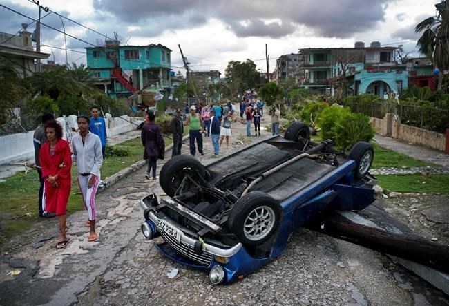 A car overturned by a tornado lays smashed on top of a street pole in Havana, Cuba, Monday, Jan. 28, 2019. A tornado and pounding rains smashed into the eastern part of Cuba's capital overnight, toppling trees, bending power poles and flinging shards of metal roofing through the air as the storm cut a path of destruction across eastern Habana.