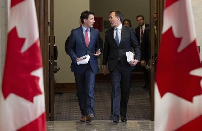 Prime Minister Justin Trudeau and Finance Minister Bill Morneau speak as they walk to the House of Commons in Ottawa, Tuesday March 19, 2019. The Liberal government is signalling its intent to stem the flow of asylum seekers crossing into Canada at unofficial entry points with a new border-enforcement strategy aimed at detecting, intercepting and removing irregular migrants.