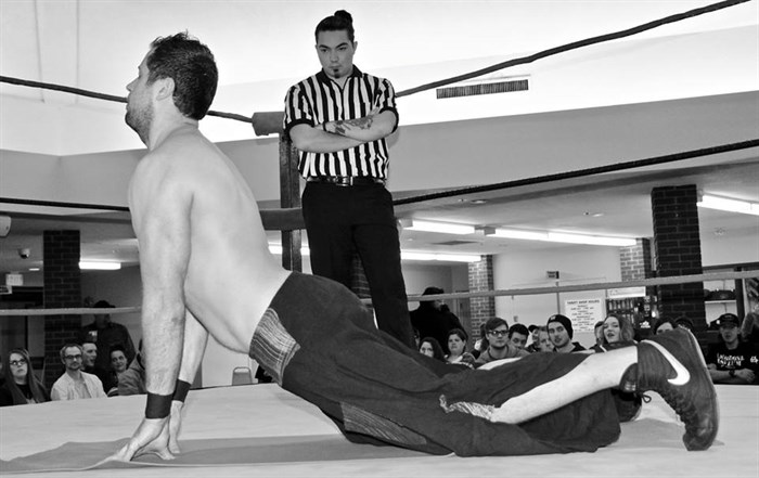 Dave Gibbs stretches out in front of a wrestling crowd.