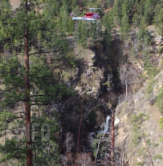 Hardy Falls can be seen in the background as a helicopter airlifts a prefabricated wooden bridge, Thursday, April 11, 2019.