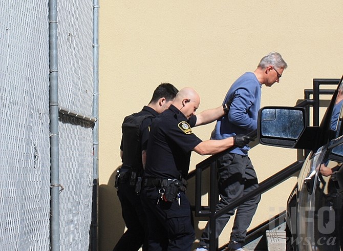 John Brittain, 60, is escorted by sheriffs into the Penticton courthouse, Tuesday, April 16, 2019. Brittain is charged with three counts of first degree murder and one count of second degree murder following a series of shootings, Monday, April 15, 2019 in the city.