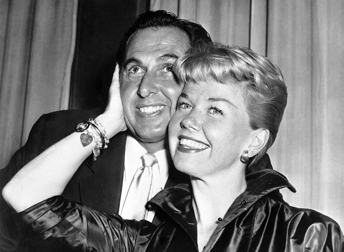 FILE - In this April 12, 1955 file photo, film actress and singer Doris Day poses with her husband and agent Martin Melcher at their hotel after arriving in London. Day, whose wholesome screen presence stood for a time of innocence in '60s films, has died, her foundation says. She was 97. The Doris Day Animal Foundation confirmed Day died early Monday, May 13, 2019, at her Carmel Valley, California, home.