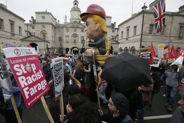 People carry signs and banners as they march through central London to demonstrate against the state visit of President Donald Trump, Tuesday, June 4, 2019. Trump will turn from pageantry to policy Tuesday as he joins British Prime Minister Theresa May for a day of talks likely to highlight fresh uncertainty in the allies' storied relationship.
