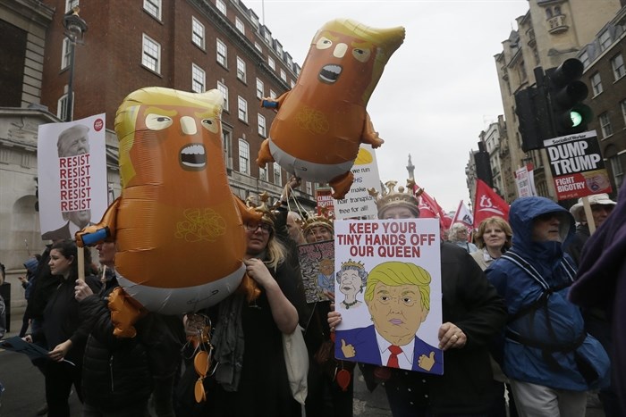 People carry signs and banners as they march through central London to demonstrate against the state visit of President Donald Trump, Tuesday, June 4, 2019. Trump will turn from pageantry to policy Tuesday as he joins British Prime Minister Theresa May for a day of talks likely to highlight fresh uncertainty in the allies' storied relationship.