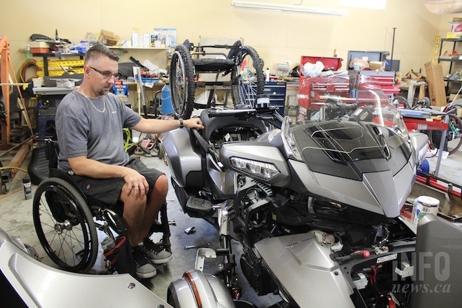 Tyler Tingle is seen working on his Spyder bike at his home in Westsyde. He modified the foot brakes into hand controls and added a wheelchair rack.