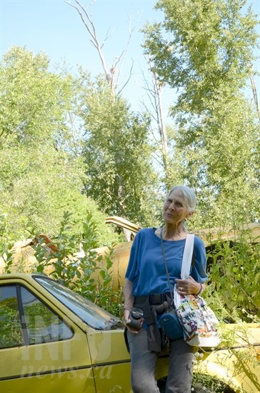 Rita Bos leans against one of the many old cars from her late husbands towing yard. The great blue herons' nest high-up on the other side of Bos' property.