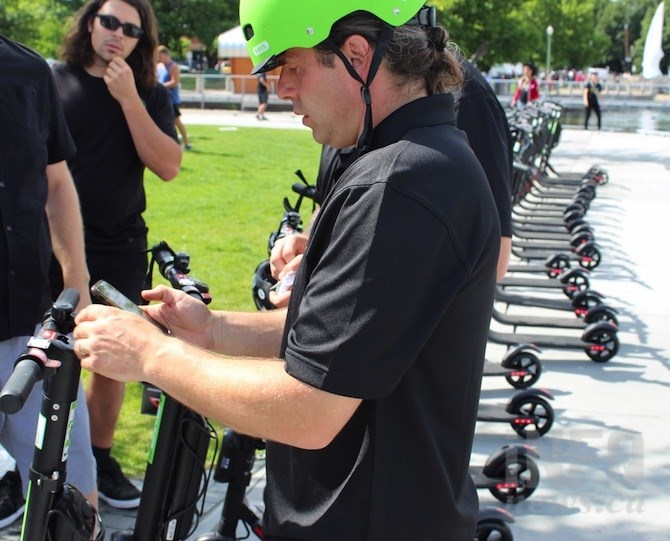 Chris Szydloski shows media how to activate the Ogo e-scooter.