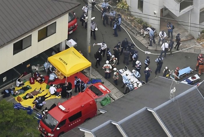 People injured in a fire are treated near a Kyoto Animation building in Kyoto, western Japan, Thursday, July 18, 2019. The fire broke out in the three-story building in Japan's ancient capital of Kyoto, after a suspect sprayed an unidentified liquid to accelerate the blaze, Kyoto prefectural police and fire department officials said.