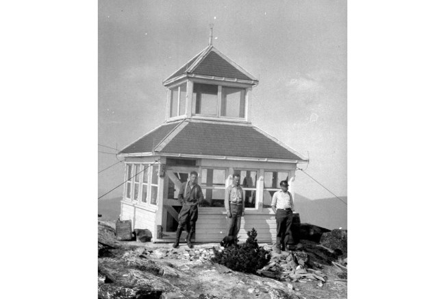 Three unidentified men stand in front of the Baldy Mountain Lookout in an undated photo. This lookout is located northast of Kamloops near Sorrento.