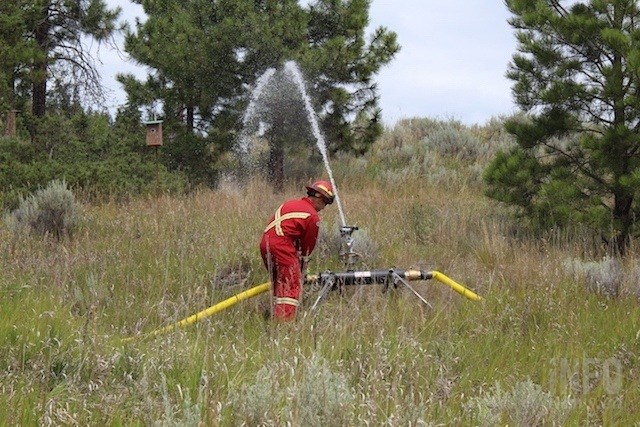 A firefighter is seen adjusting a Firebozz sprinkler at a Kamloops Fire Rescue demonstration on Thursday, July 25, 2019 at the Dufferin Wetlands. 