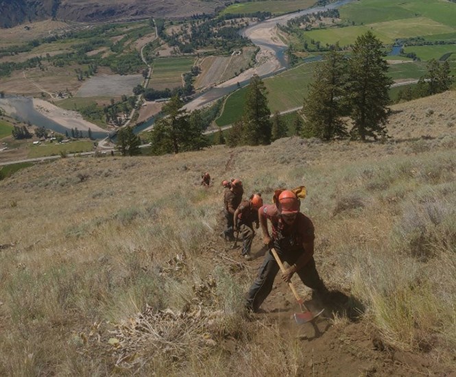 Wildfire crews work to build a fireguard around the Richter Mountain wildfire.