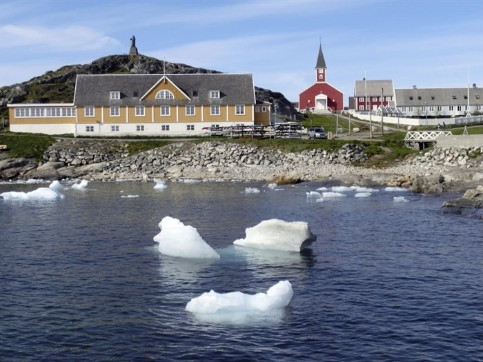 In this image taken on June 13, 2019 small pieces of ice float in the water off the shore in Nuuk, Greenland.