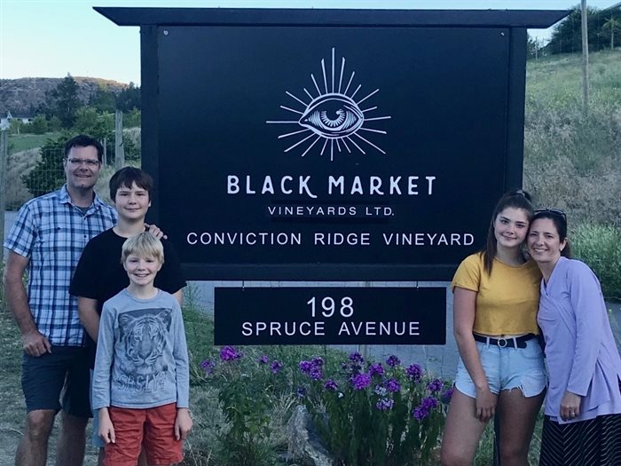 Rob & Michelle with their family standing on their new Kaleden vineyard