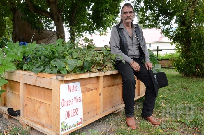 Dirty Hoe Farms owner Dan Hill sits on one of his rental gardens.