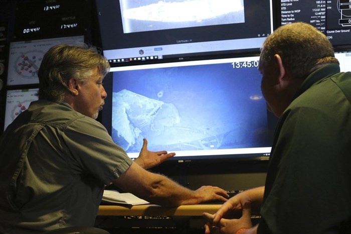In this Wednesday, Oct. 16, 2019 photo, Vulcan Inc. director of undersea operations for the Petrel, Rob Kraft, left, and the Naval History and Heritage Command's Frank Thompson, left, look at footage of the Japanese aircraft carrier Kaga, off Midway Atoll in the Northwestern Hawaiian Islands.
