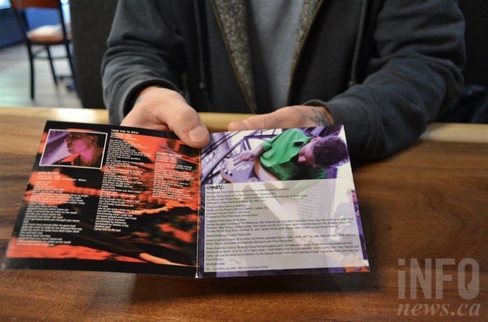 Giles holds the lyric page from the Imaginary Friend CD. He is pictured on the left-hand side, while bandmate and late friend Sean Wilson is pictured on the right.