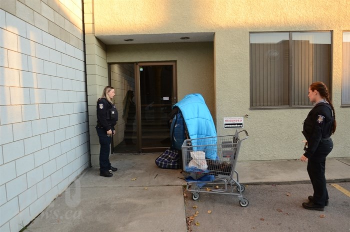 Officers Candace Brandt and Justine Baumgart move a homeless man from a doorway in Vernon.