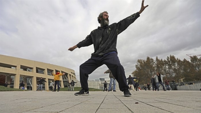 In this Oct. 2, 2019, photo, David Christopher Coons performs tai chi at the Salt Lake City Main Library, in Salt Lake City. The participants are homeless people who take part in a free tai chi program run by a retired couple who started the classes three years earlier. Coons was fired from his job as an electrician about five years ago. He has been homeless since, vacillating between sleeping in shelters or on the streets of Salt Lake City. 