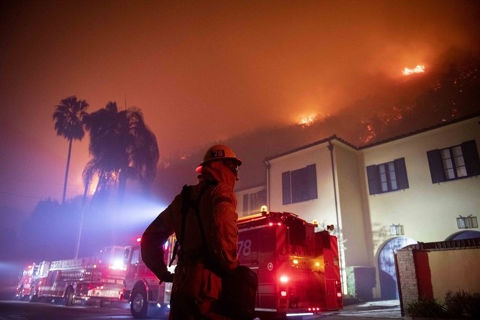 A firefighter watches flames approach the Mandeville Canyon neighborhood during the Getty fire, Monday, Oct. 28, 2019, in Los Angeles, Calif.