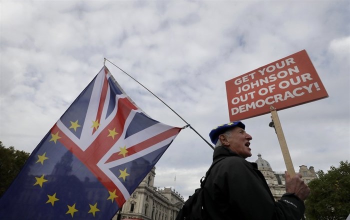 An anti-brexit demonstrator holds a banner outside Parliament in London, Monday, Oct. 28, 2019. British Prime Minister Boris Johnson says it's Parliament's fault, not his, that Britain will not be leaving the European Union as scheduled on Oct. 31. The EU has agreed to postpone Brexit until Jan. 31 after Johnson failed to get British lawmakers to ratify his divorce deal with the bloc in time to leave this week. 