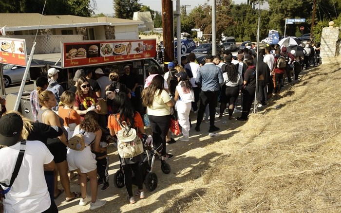 People line up around the block of singer Chris Brown's home in the Tarzana area of Los Angeles Wednesday, Nov. 6, 2019.