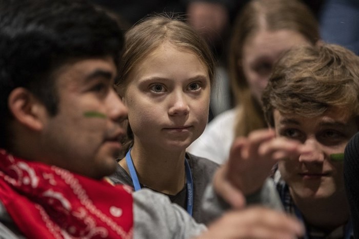 Climate activist Greta Thunberg, center, talks with other climate activists youth at the COP25 climate talks summit in Madrid, Friday, Dec. 6, 2019. Thunberg arrived in Madrid Friday to join thousands of other young people in a march to demand world leaders take real action against climate change. 
