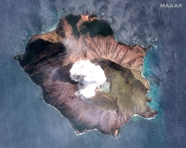 In this satellite image taken and released on Dec. 12, 2019, by Maxar Technologies steam rises from the volcano on White Island off the coast of Whakatane, New Zealand. A New Zealand island volcano vented more steam and mud Wednesday in an increase of geothermal activity that again delayed the recovery of victims' bodies from a deadly eruption two days ago. 