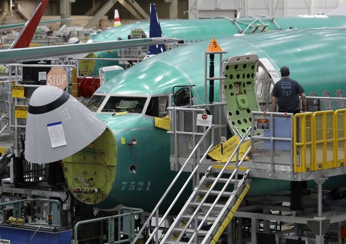 FILE - In this March 27, 2019, file photo, a worker enters a Boeing 737 MAX 8 airplane during a brief media tour of Boeing's 737 assembly facility in Renton, Wash. On Monday, Dec. 16, shares of Boeing are falling before the opening bell on a report that the company may cut production of its troubled 737 Max or even end production all together.
