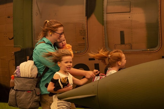 In this Jan. 4, 2020 photo provided by the Australian Department of Defence, a woman and three children prepare to board an Australian Army Blackhawk helicopter in Omeo, Victoria, Australia, for evacuation from the wildfire effected area. The wildfires have so far scorched an area twice the size of the U.S. state of Maryland. 
