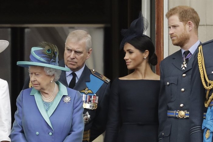 FILE - In this Tuesday, July 10, 2018 file photo Britain's Queen Elizabeth II, Prince Andrew, Meghan the Duchess of Sussex and Prince Harry stand on a balcony to watch a flypast of Royal Air Force aircraft pass over Buckingham Palace in London. As part of a surprise announcement distancing themselves from the British royal family, Prince Harry and his wife Meghan declared they will 