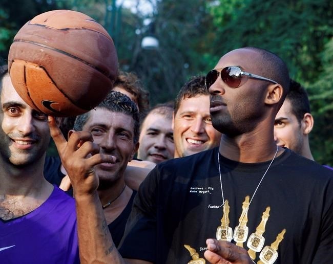 FILE - In this Sept. 28, 2011, file photo, U.S. basketball star Kobe Bryant plays with a ball during a sponsor's appearance in Milan, Italy. In Europe where Bryant grew up, the retired NBA star is being remembered for his 