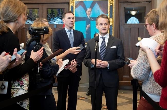 Minister of Finance Bill Morneau looks on as Natural Resources Minister Seamus O'Regan responds to a question from the media in Ottawa, Tuesday, February 4, 2020. 