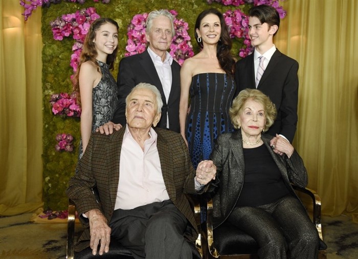 FILE - This Dec. 9, 2016 file photo shows actor Kirk Douglas, seated left, holding hands with his wife Anne Douglas, seated right, as they pose with family members, their son Michael, standing second left, his wife Catherine Zeta-Jones, standing second and their children, Carys, left, and son Dylan during Kirk's 100th birthday party in Beverly Hills, Calif. Kirk Douglas died Wednesday, Feb. 5, 2020 at age 103. 