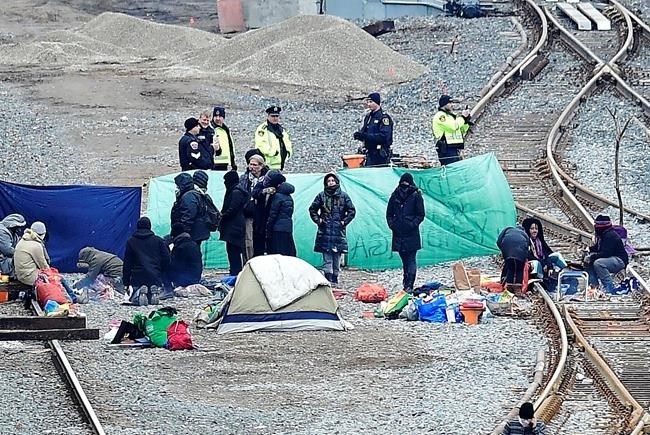 Police speak with protesters camped on GO Transit railroad tracks in Hamilton, Ont., on Tuesday, Feb. 25, 2020, as they protest in solidarity with Wet'suwet'en Nation hereditary chiefs attempting to halt construction of a natural gas pipeline on their traditional territories.