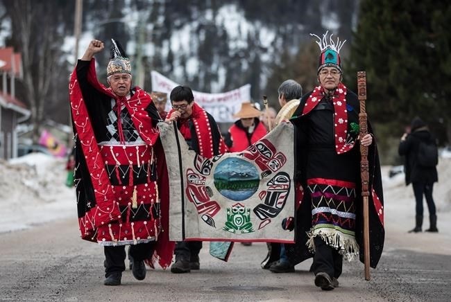 Chief Madeek (Jeff Brown), front left, hereditary leader of the Gidimt'en clan, and Wet'suwet'en Hereditary Chief Namoks (John Ridsdale), front right, carry a flag while leading a solidarity march after Indigenous nations and supporters gathered for a meeting to show support for the Wet'suwet'en Nation, in Smithers, B.C., on Wednesday January 16, 2019. 