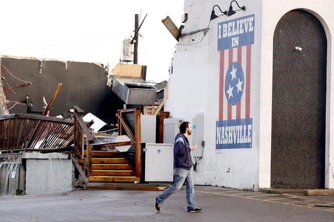 A man walks by The Basement East, a live music venue destroyed by storms Tuesday, March 3, 2020, in Nashville, Tenn. Tornadoes ripped across Tennessee early Tuesday, shredding buildings and killing multiple people. 