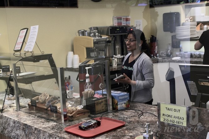 Soleda Flores at Molly’s Cafe takes orders while standing behind a plexiglass shield that reaches to the ceiling, Tuesday, May 19, 2020.
