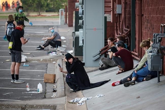 Protestors react after being exposed to tear gas fired by police, Thursday, May 28, 2020, in St. Paul, Minn. Protests over the death of George Floyd, a black man who died in police custody Monday, broke out in Minneapolis for a third straight night. 