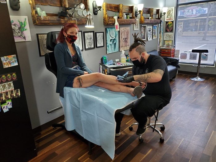 Jullian Greenman works on his client's tattoo at Sakred Skin. 