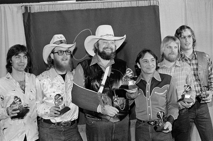FILE - Charlie Daniels, center, joins members of the Charlie Daniels Band with their Grammy Awards in Los Angeles on Feb. 27, 1980, as best country vocal performance by a group for their hit 