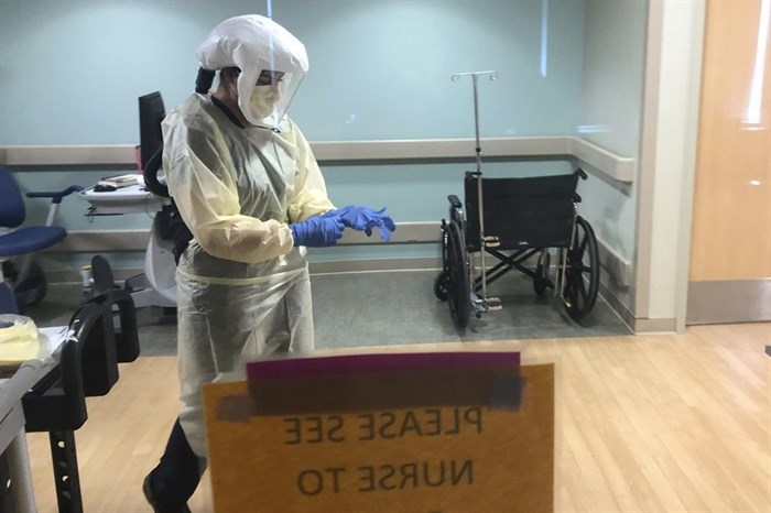In this photo provided by the UPMC, Dr. Ruba Nicola, chairwoman of family medicine at UPMC East, adjusts her personal protective equipment at the UPMC East hospital in Monroeville, Pa., on April 17, 2020.